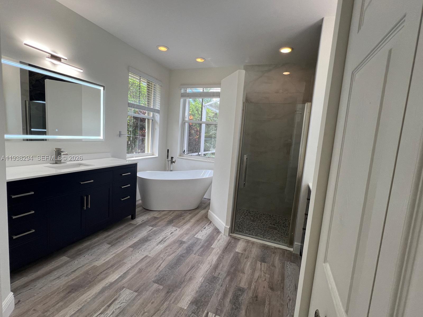 2408 Deer Creek Road Weston, FL 33327 - Photo 18 of 30 a bathroom with a double vanity sink toilet mirror and bathtub