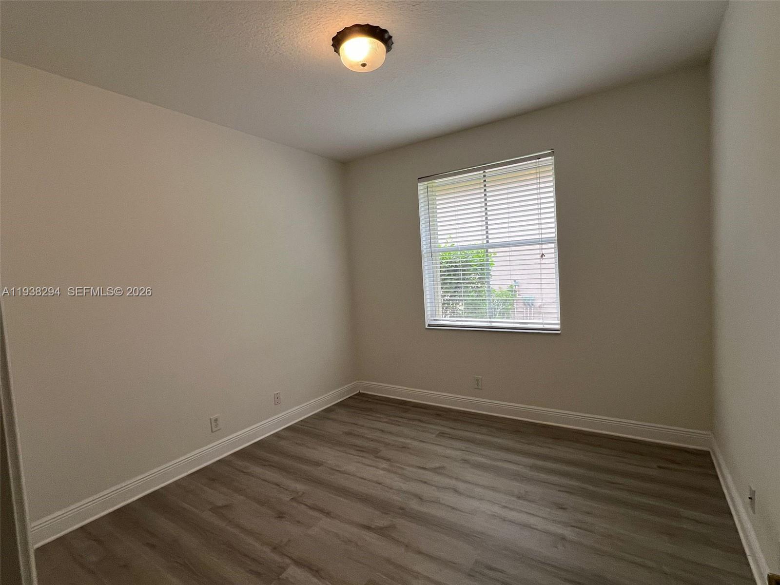 2408 Deer Creek Road Weston, FL 33327 - Photo 20 of 30 an empty room with wooden floor and windows