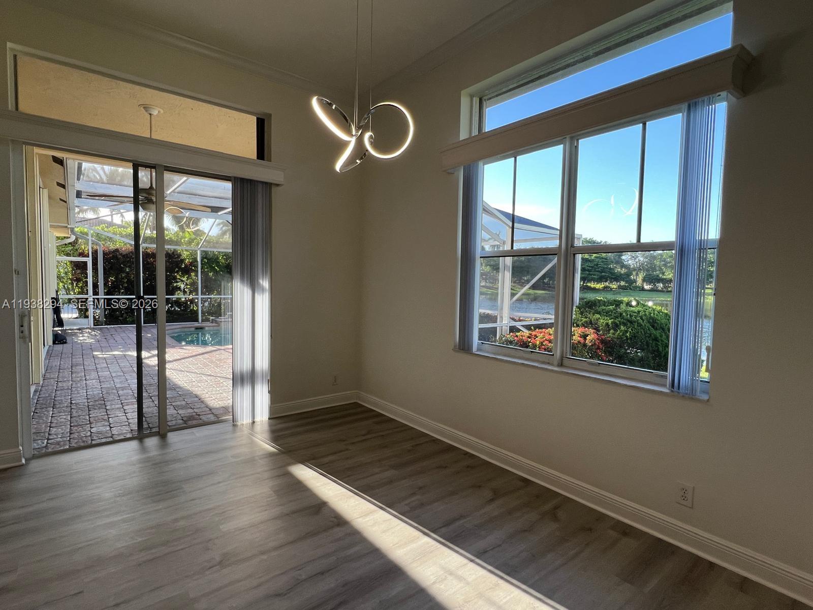 2408 Deer Creek Road Weston, FL 33327 - Photo 22 of 30 a view of an empty room with wooden floor and a window