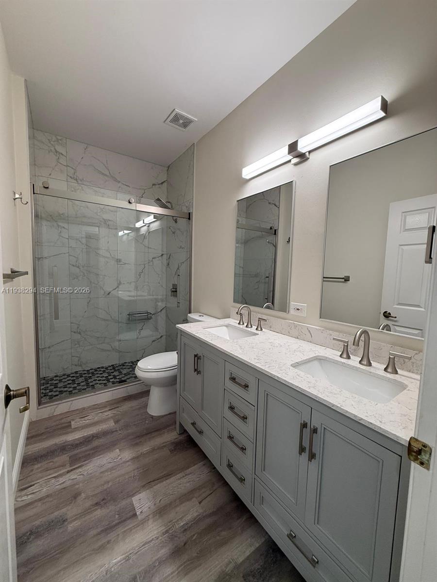 2408 Deer Creek Road Weston, FL 33327 - Photo 26 of 30 a bathroom with a double vanity sink toilet mirror and shower