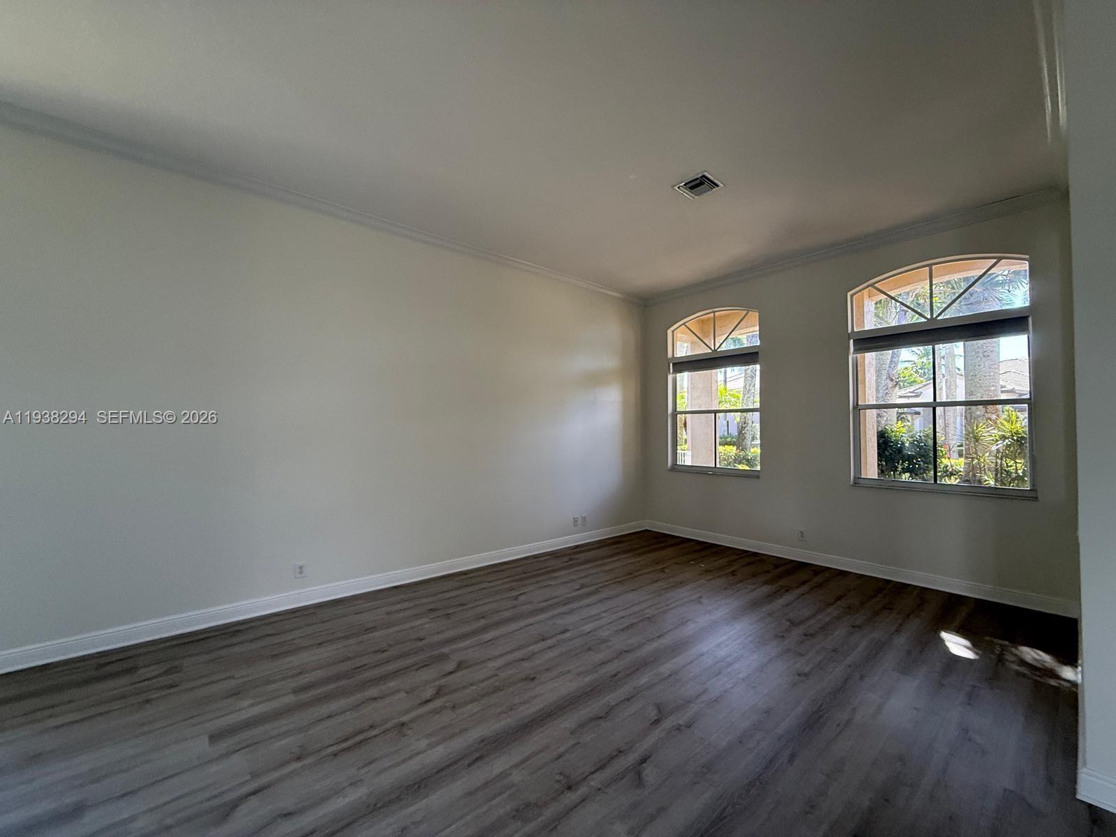 2408 Deer Creek Road Weston, FL 33327 - Photo 5 of 30 a view of an empty room with wooden floor and a window