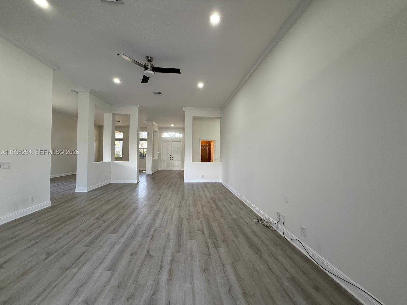 2408 Deer Creek Road Weston, FL 33327 - Photo 6 of 30 an empty room with wooden floor and windows