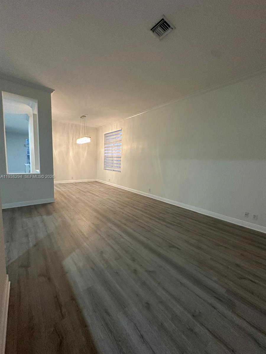 2408 Deer Creek Road Weston, FL 33327 - Photo 10 of 30 a view of an empty room with wooden floor and a window