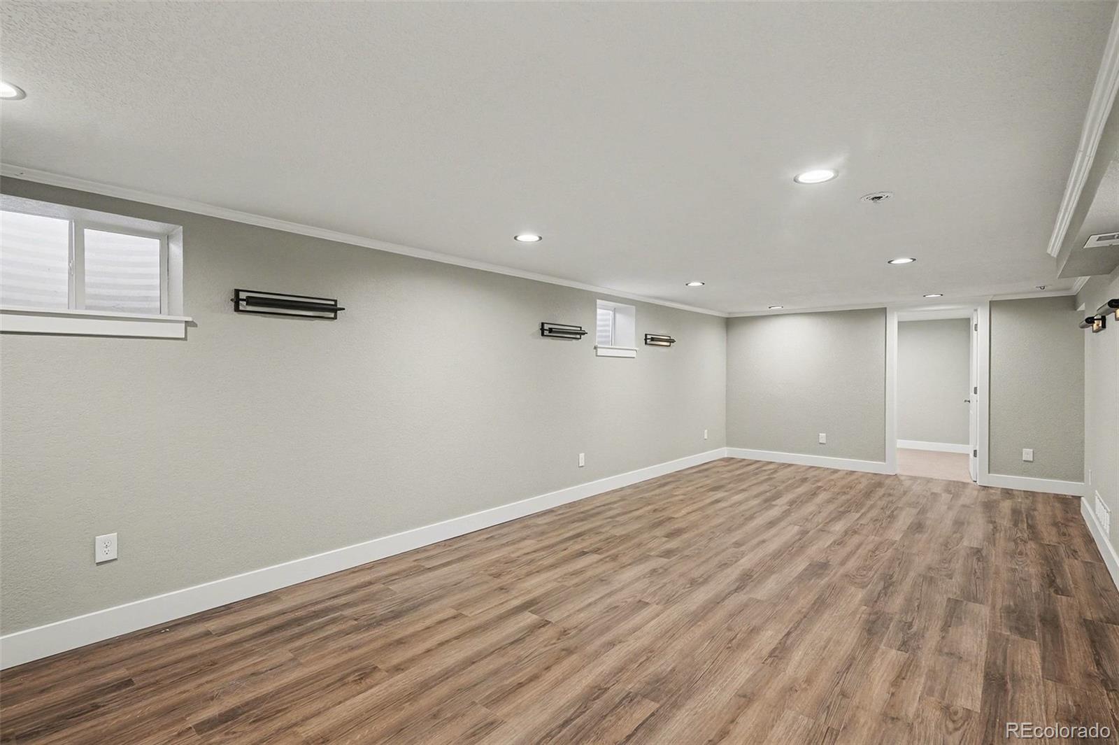 2580 South Perry Street Denver, CO 80219 - Photo 20 of 28 a view of empty room with wooden floor and fan