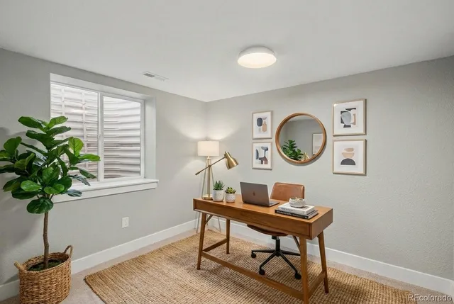 a view of a workspace with a table and a potted plant