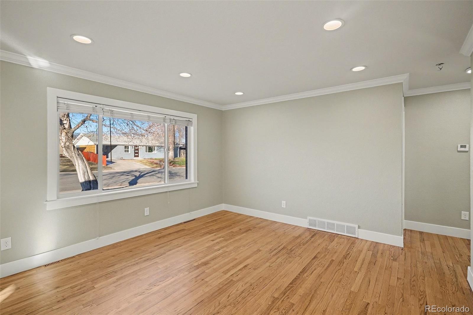 2580 South Perry Street Denver, CO 80219 - Photo 3 of 28 a view of room with window and wooden floor