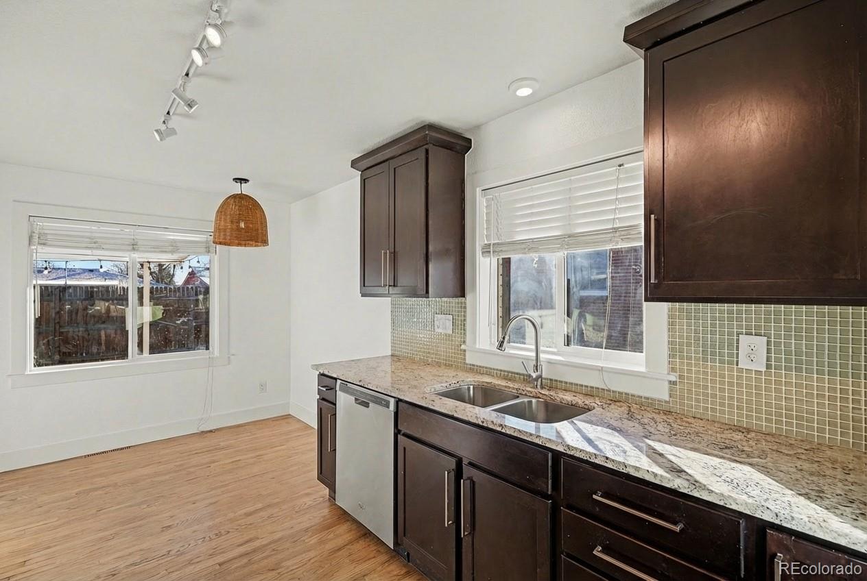 2580 South Perry Street Denver, CO 80219 - Photo 7 of 28 a kitchen with granite countertop a sink a stove and wooden floor