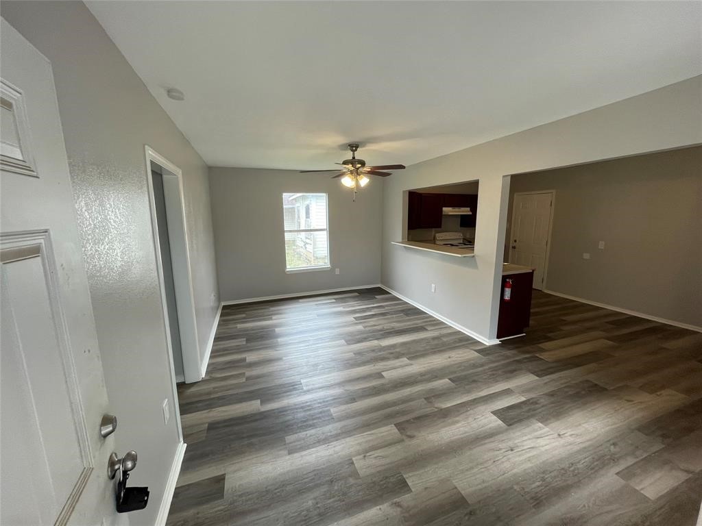 a view of a livingroom with wooden floor and window