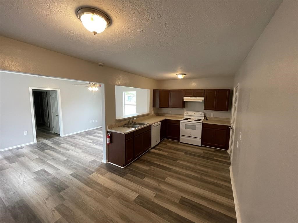 1708 West 5th Street Freeport, TX 77541 - Photo 2 of 9 a large kitchen with kitchen island granite countertop a stove top oven and sink