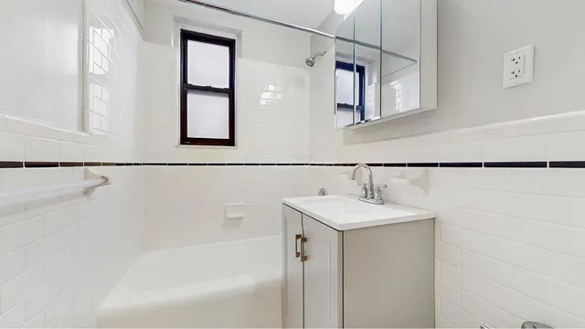a kitchen with white cabinets and black appliances