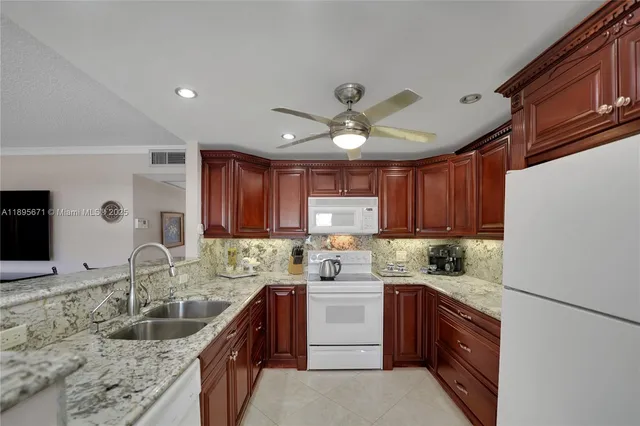 a kitchen with granite countertop wooden cabinets and refrigerator