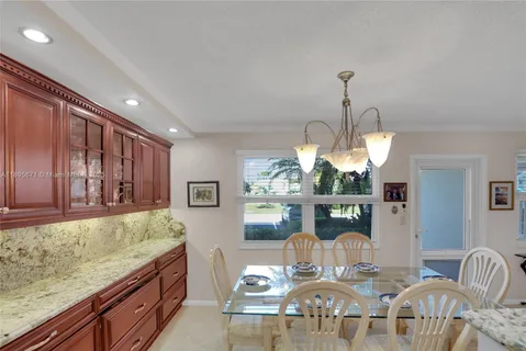 a kitchen with refrigerator and chairs