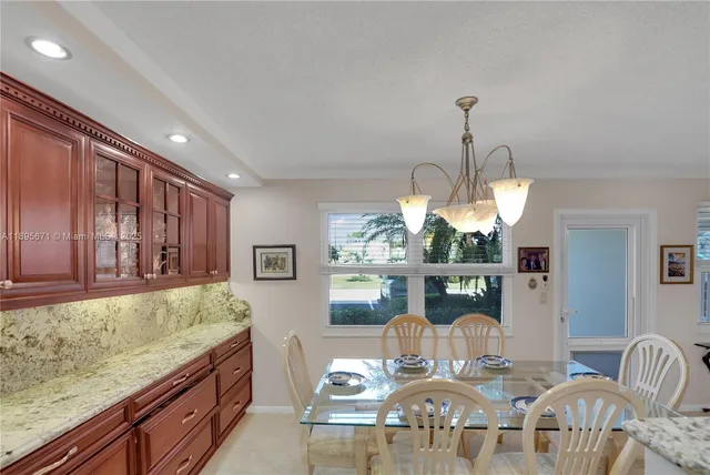 a kitchen with refrigerator and chairs