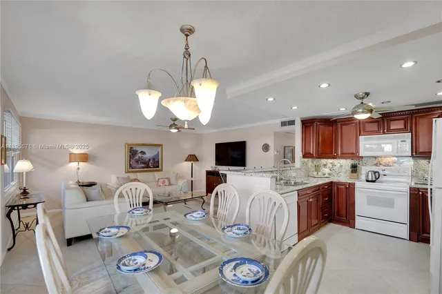 a large room with kitchen island a chandelier a sink a dining table and chairs
