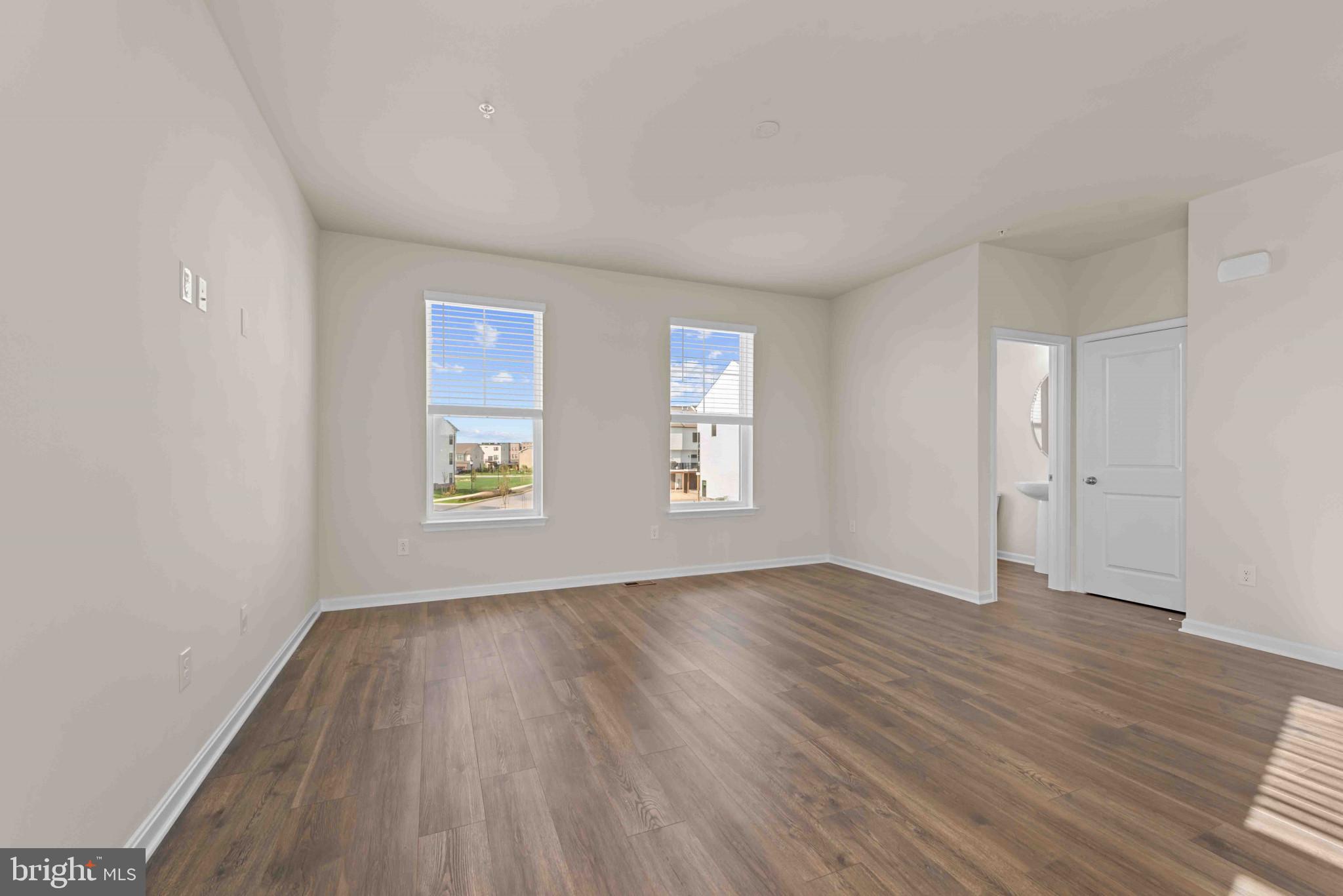 377 Ensemble Way Frederick, MD 21701 - Photo 16 of 45 a view of an empty room with wooden floor and a window