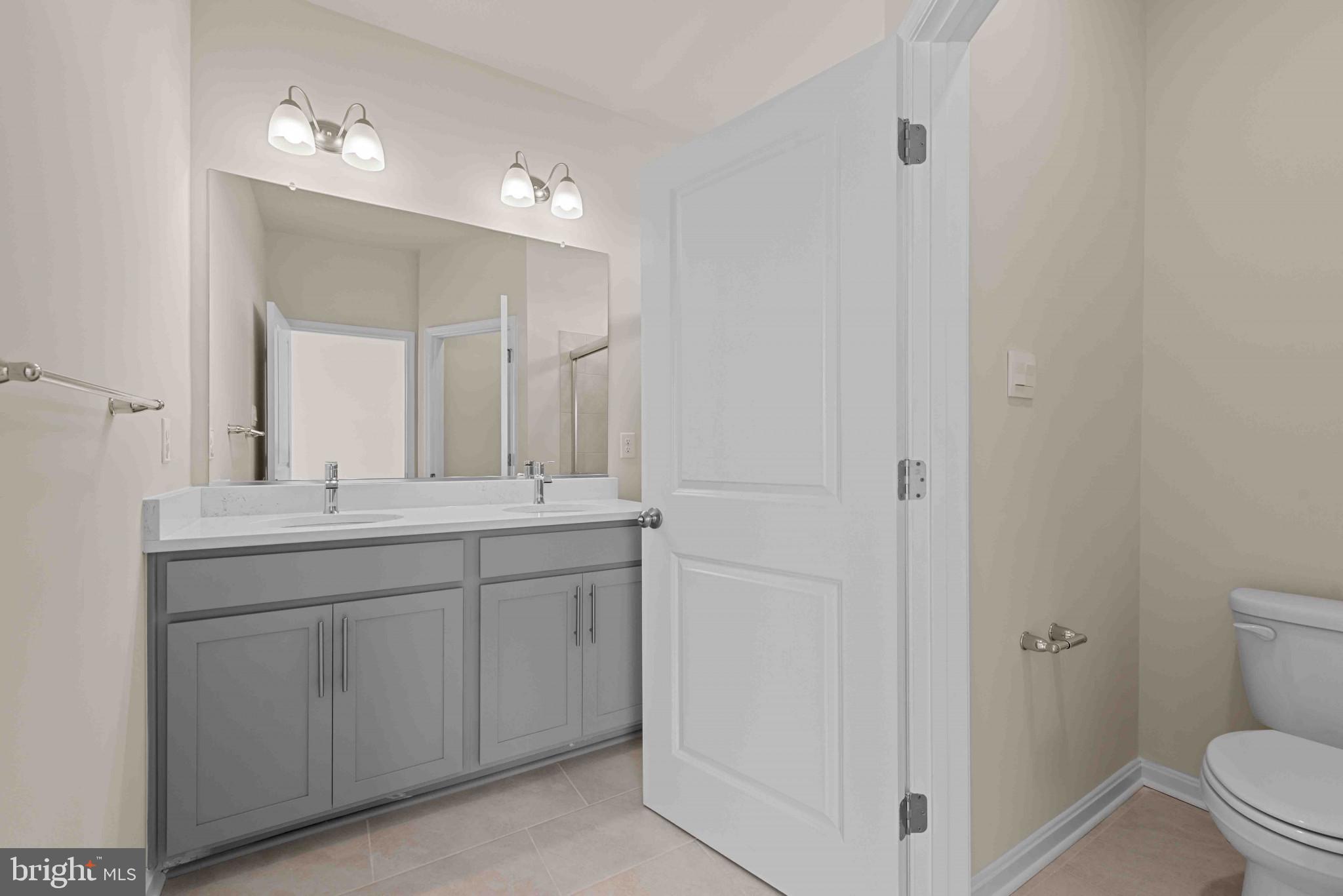 377 Ensemble Way Frederick, MD 21701 - Photo 30 of 45 a bathroom with a granite countertop sink a toilet and a mirror