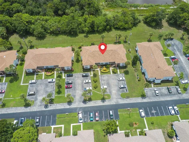 an aerial view of residential houses with outdoor space and trees