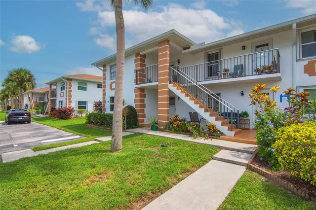 a front view of a house with a yard and tree s