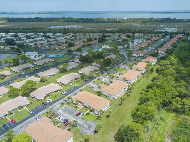 an aerial view of residential houses with outdoor space and trees