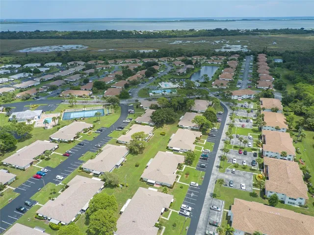 an aerial view of residential houses with outdoor space and trees
