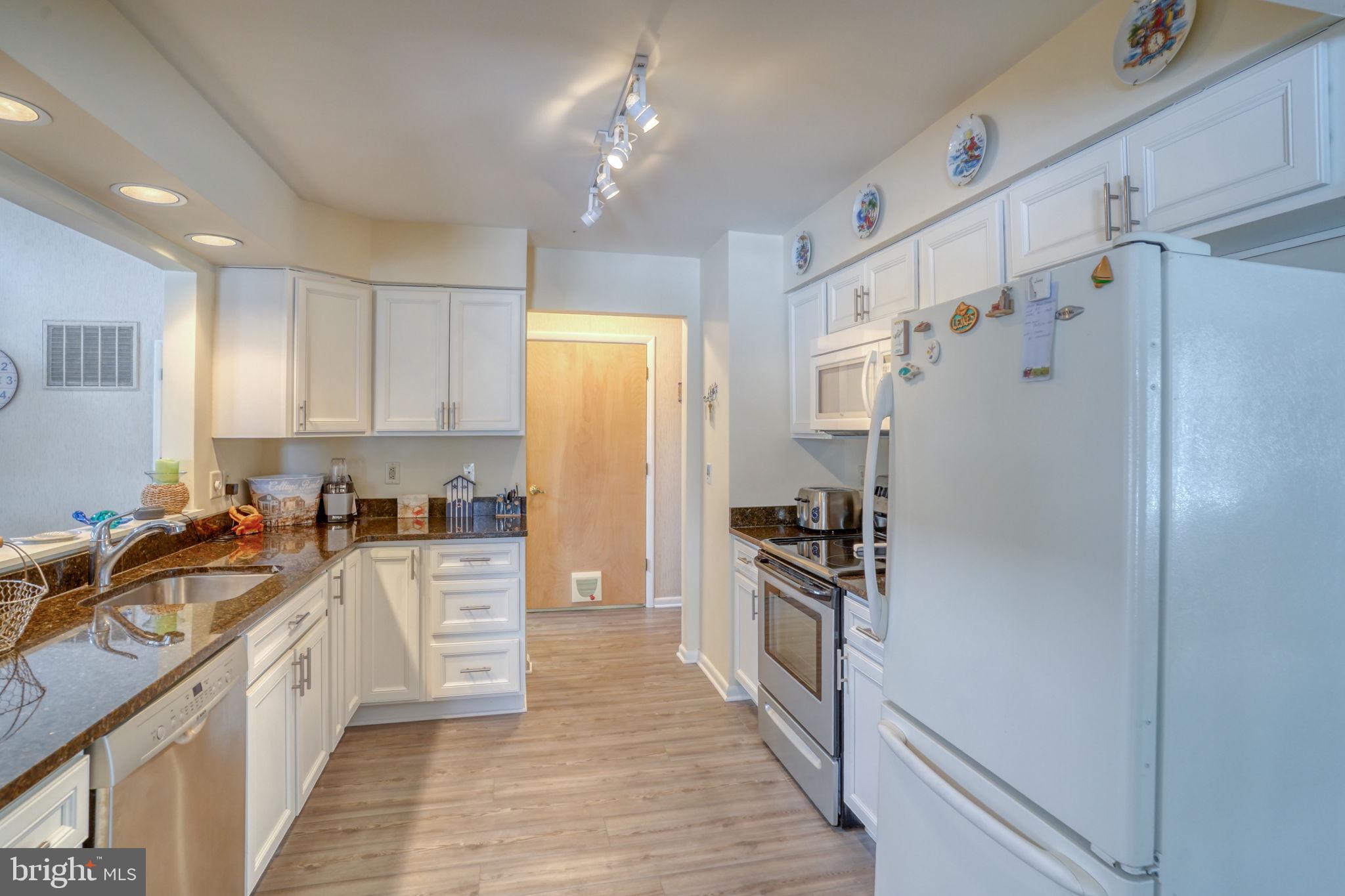18488 Belle Grove Road, Unit 3 Lewes, DE 19958 - Photo 14 of 48 a kitchen with granite countertop a refrigerator stove and sink