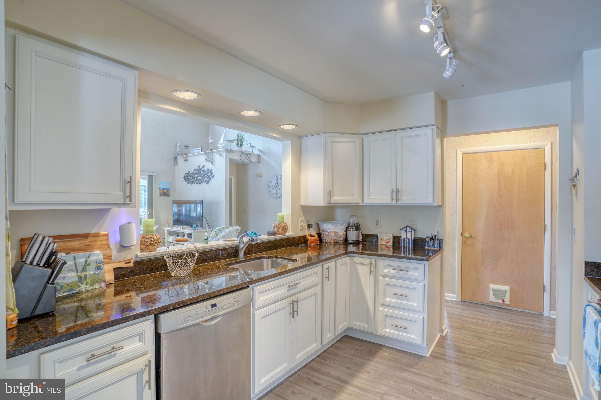 18488 Belle Grove Road, Unit 3 Lewes, DE 19958 - Photo 15 of 48 a kitchen with granite countertop a sink stainless steel appliances and cabinets