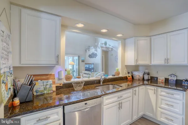 a kitchen with white cabinets and sink