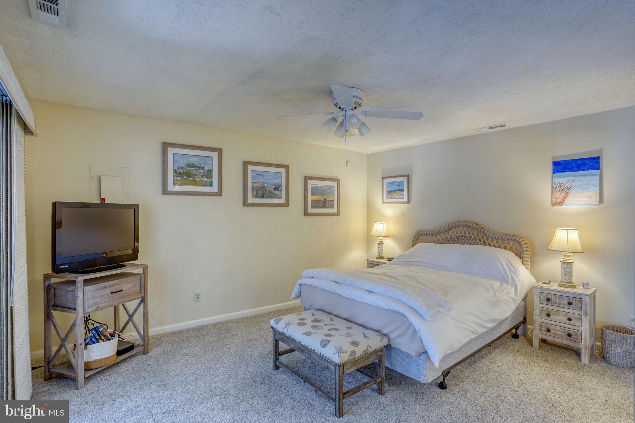 18488 Belle Grove Road, Unit 3 Lewes, DE 19958 - Photo 29 of 48 a bedroom with a bed and a flat screen tv