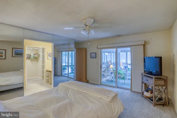 a spacious bedroom with a bed and glass door
