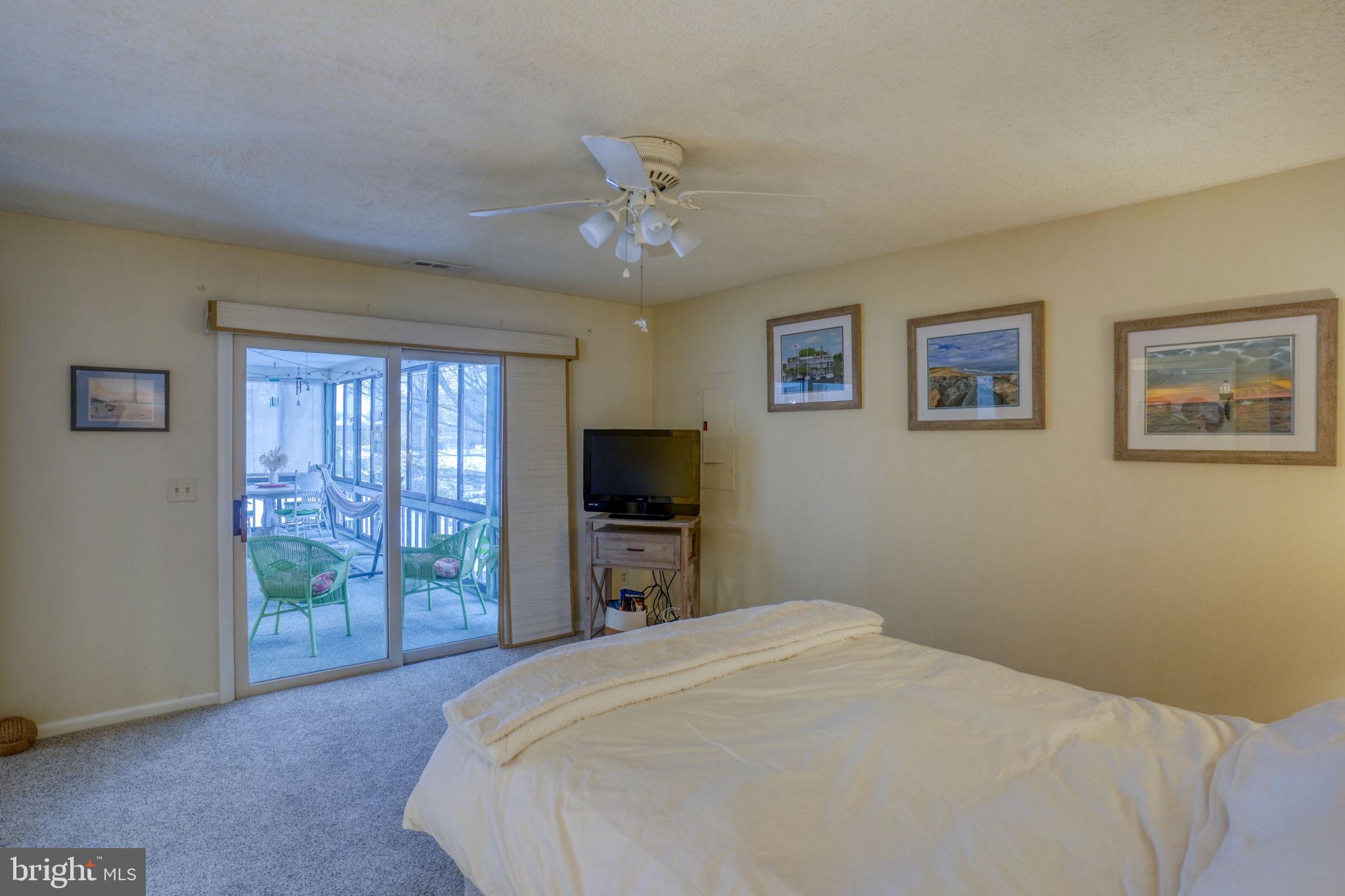 18488 Belle Grove Road, Unit 3 Lewes, DE 19958 - Photo 32 of 48 a bedroom with a large bed and a flat tv screen
