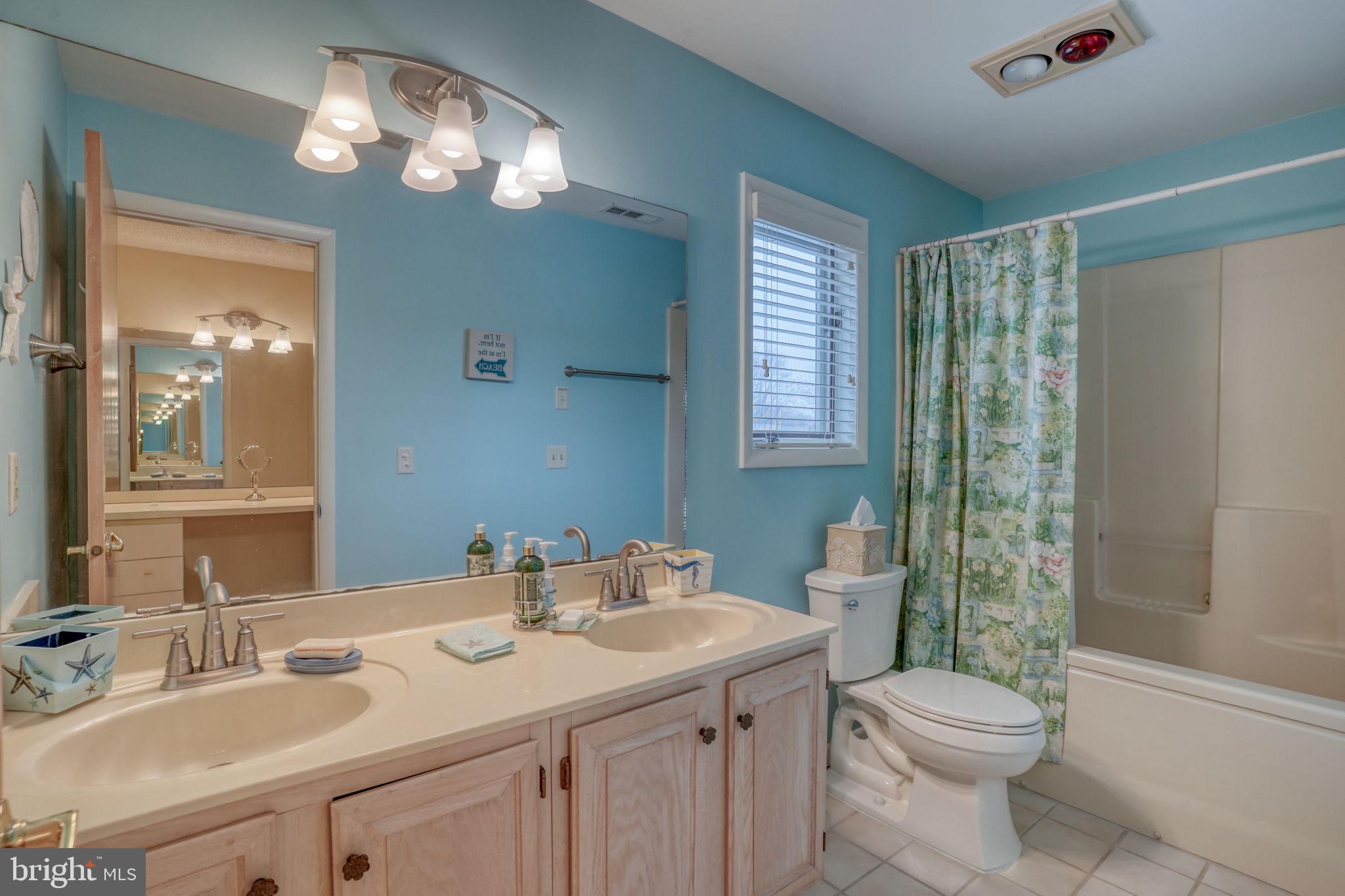 18488 Belle Grove Road, Unit 3 Lewes, DE 19958 - Photo 34 of 48 a bathroom with a sink a toilet a mirror a vanity and shower