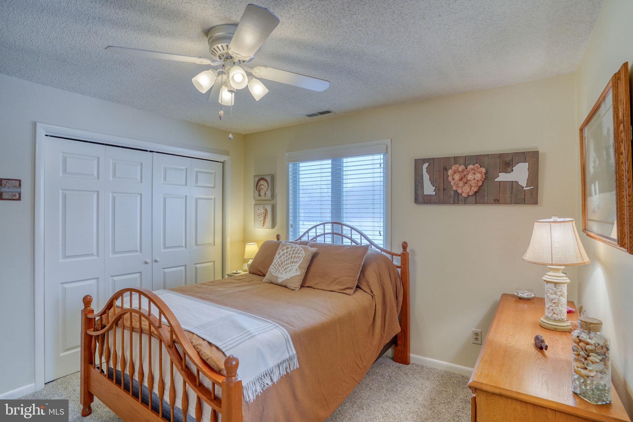 18488 Belle Grove Road, Unit 3 Lewes, DE 19958 - Photo 38 of 48 a bedroom with a bed and a chandelier