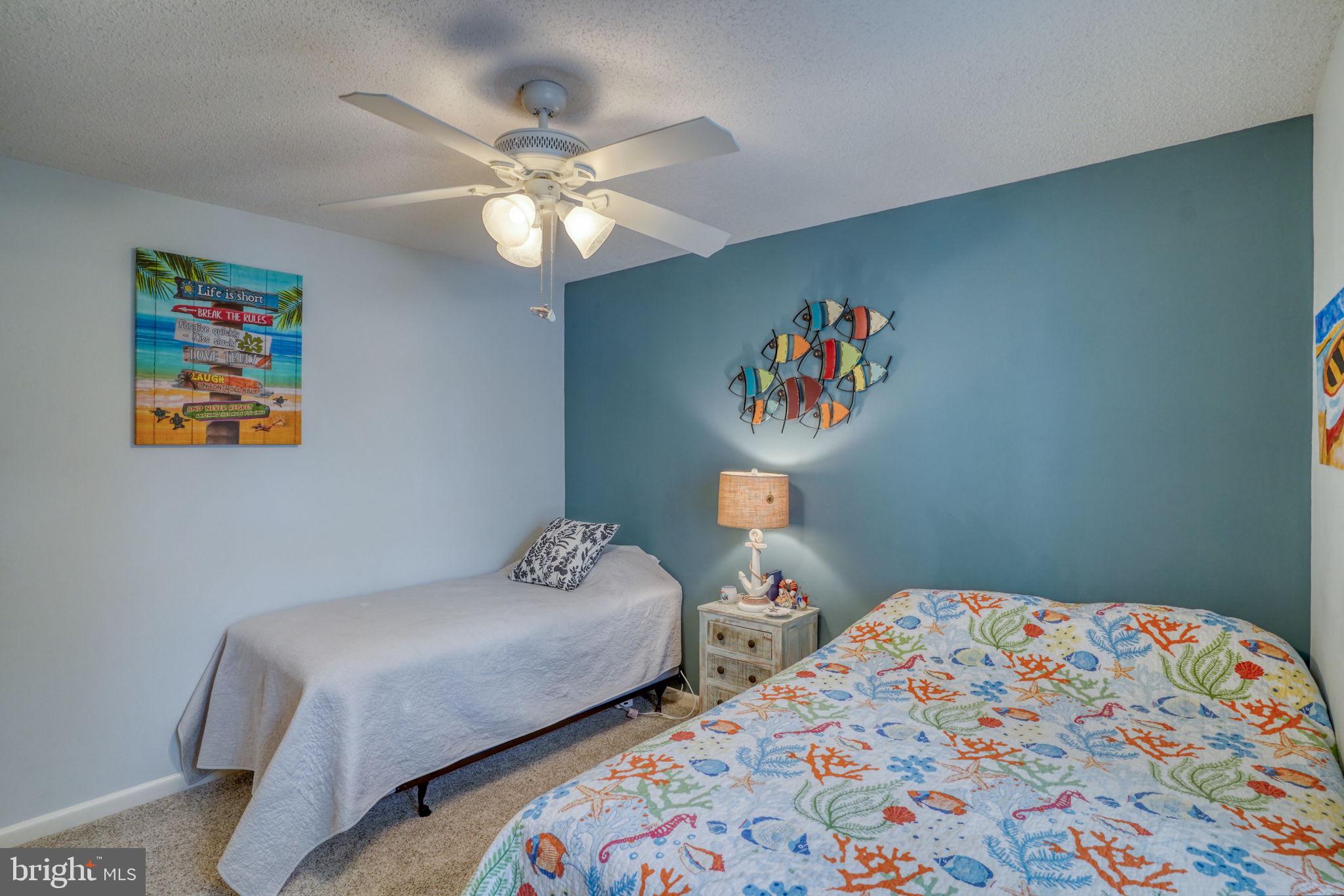 18488 Belle Grove Road, Unit 3 Lewes, DE 19958 - Photo 41 of 48 a bedroom with two beds and a chandelier