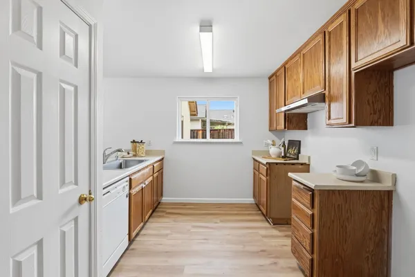 a kitchen with granite countertop a sink stove and cabinets