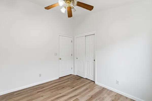 a view of empty room with wooden floor