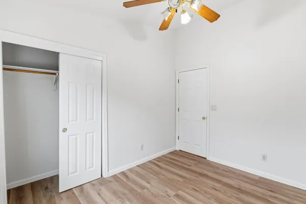 a view of empty room with wooden floor