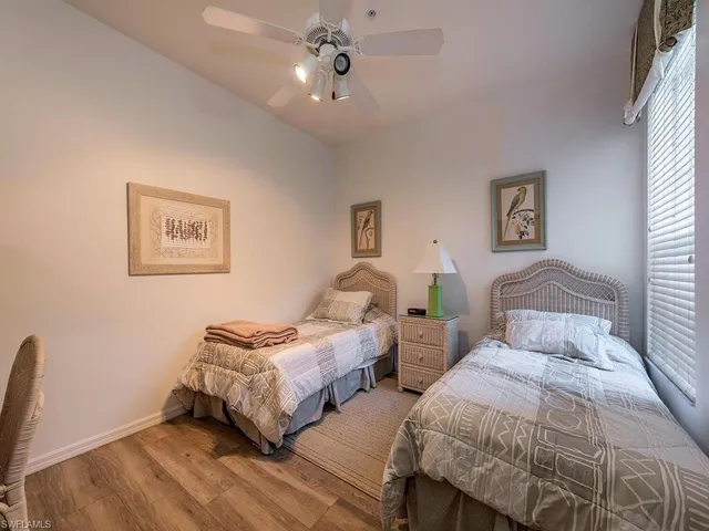 a bedroom with two beds and a chandelier