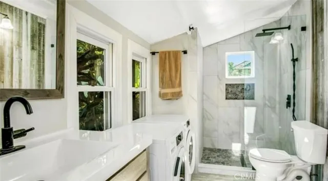 a bathroom with a granite countertop sink a toilet and shower