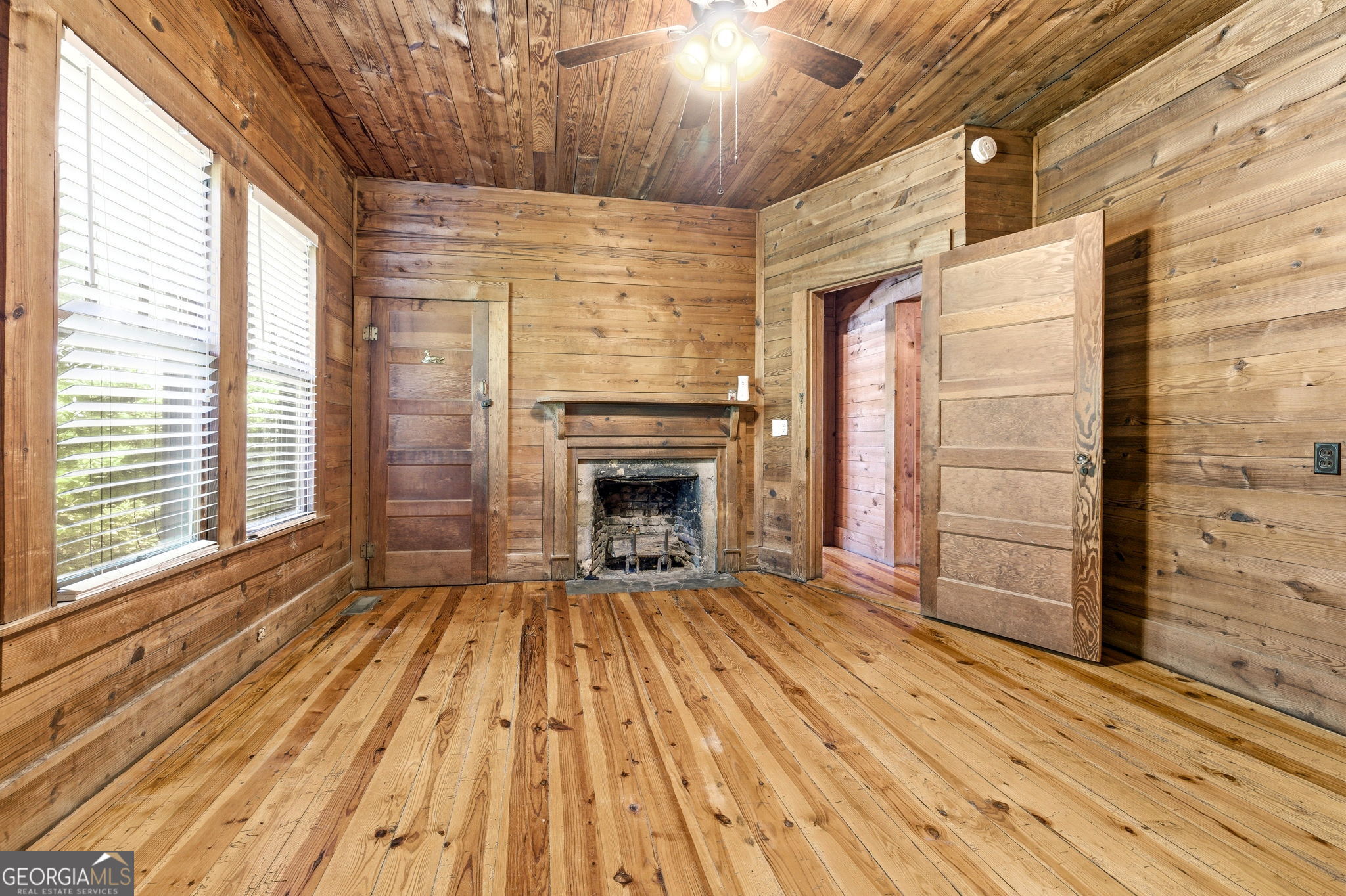 3213 Highway 326 Commerce, GA 30530 - Photo 11 of 40 a view of an empty room with wooden floor fireplace and a window