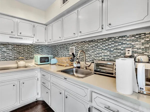 a kitchen with white cabinets and white appliances