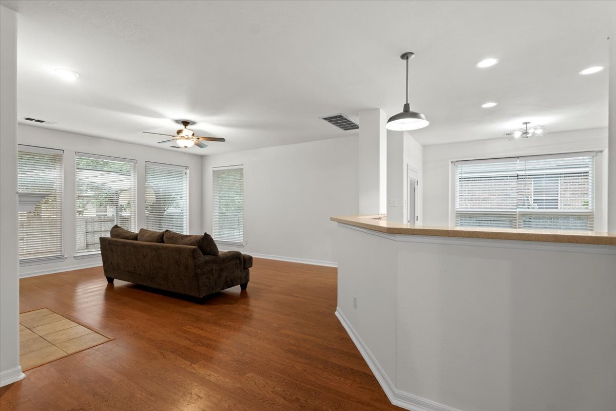 2304 Village View Loop Pflugerville, TX 78660 - Photo 16 of 40 Rich hardwood floors unite an open concept living space with a pass-through bar.