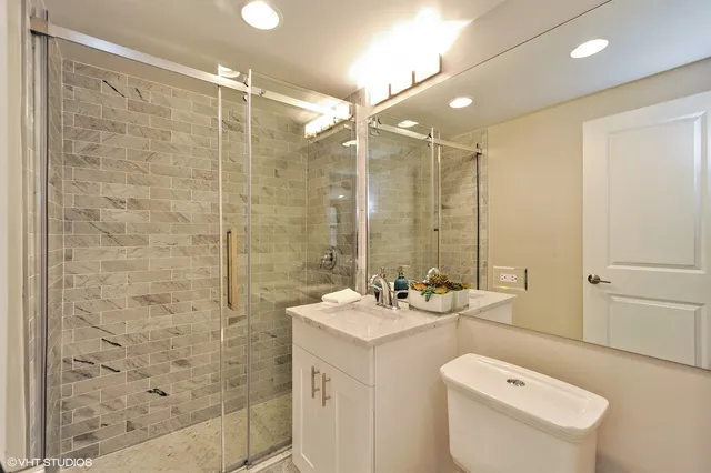 a bathroom with a sink mirror toilet and shower