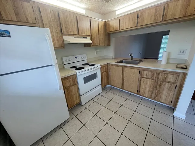 a kitchen with stainless steel appliances a stove a sink and a refrigerator