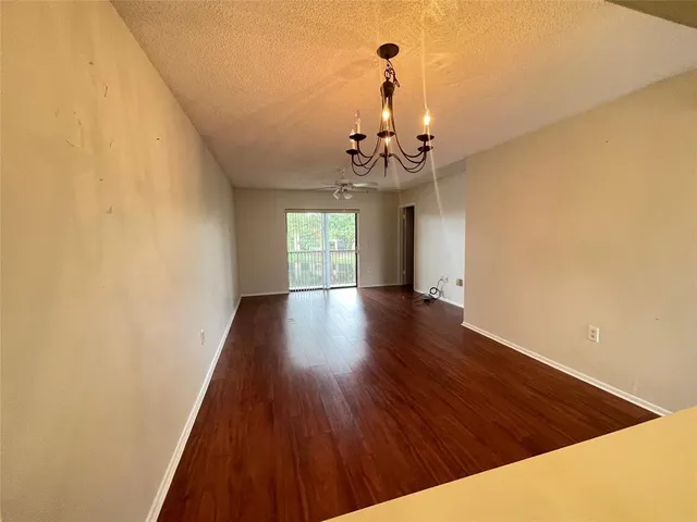 a view of a livingroom with wooden floor and chandelier