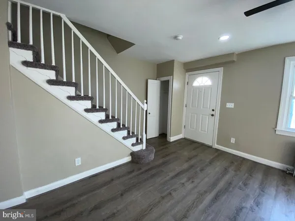 a view of a hallway with wooden floor and entryway