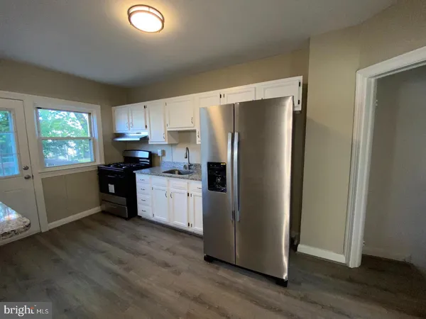 a kitchen with a refrigerator sink and cabinets
