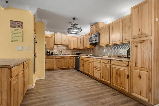 a kitchen with stainless steel appliances granite countertop a refrigerator a stove and a sink with cabinets