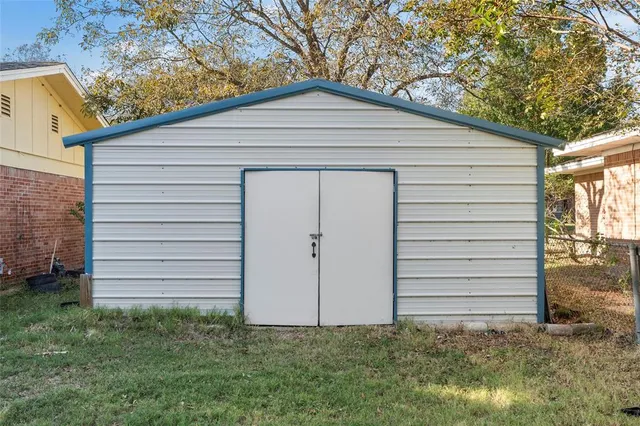 a view of a white house with a small yard and large tree