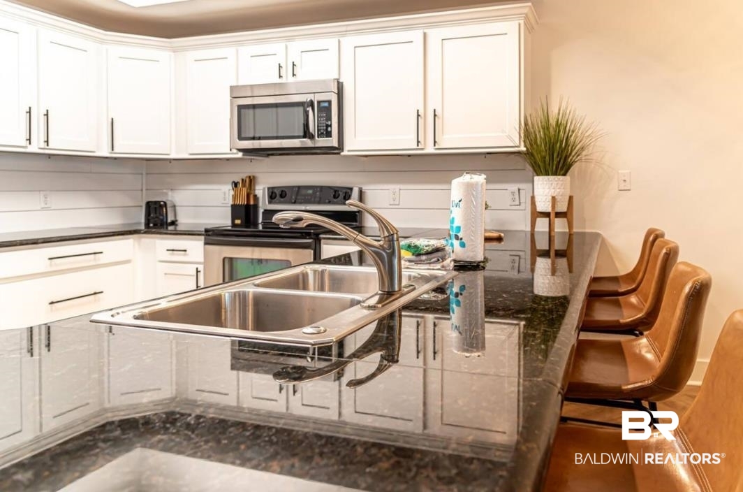 27800 Canal Road, Unit 212 Orange Beach, AL 36561 - Photo 5 of 43 Kitchen featuring white cabinetry and appliances with stainless steel finishes