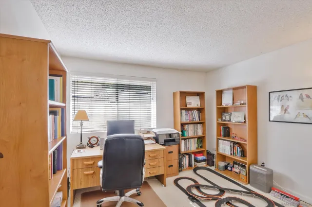 a view of a workspace with furniture and a window